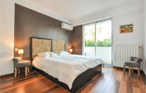 een slaapkamer met een groot bed en 2 stoelen bij 1 Bedroom Cozy Apartment In Cannes in Cannes