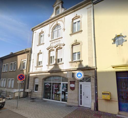 un edificio blanco con una torre de reloj encima en Les toits - Audun le Tiche - Appartement 3 chambres, en Audun-le-Tiche