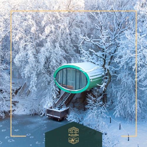 a ski lift in the snow with snow covered trees at AKIS namelis medyje- Dinosaur Park in Radailiai