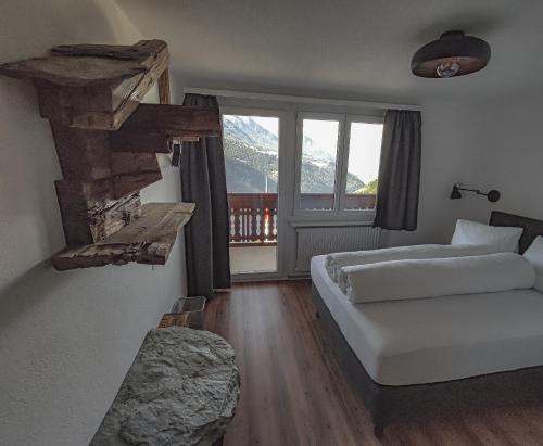a hotel room with two beds and a window at Berghotel Weisshorn in Törbel