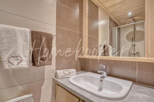 a bathroom with a sink and a mirror at Appartement Amour in Megève