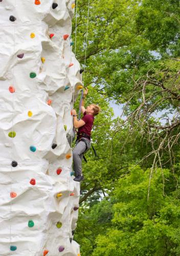 a woman is climbing on a climbing wall at Oglebay Resort in Wheeling