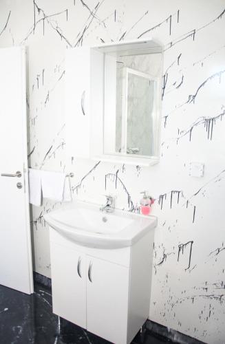 a bathroom with black and whiteigraphy on the wall at Motel Aura in Višegrad