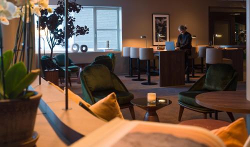 a woman sitting at a table in a hotel room at Skarsnuten Mountain Resort & SPA in Hemsedal