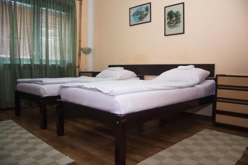 two twin beds in a room with a window at Motel Aura in Višegrad
