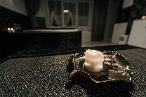 a candle sitting on top of a table at Kiss Apartment in Šilutė