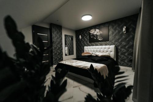 1 dormitorio con 1 cama con pared en blanco y negro en Kiss Apartment en Šilutė