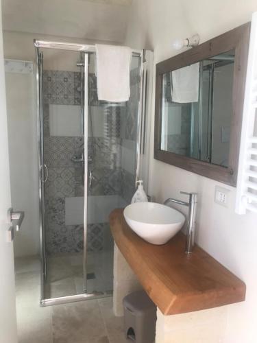 uma casa de banho com um lavatório e um chuveiro em Pignarè em Locorotondo