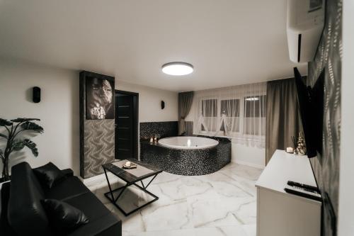 a large bathroom with a tub and a table at Kiss Apartment in Šilutė