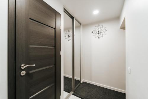 a hallway with a wooden door in a house at Kiss Apartment in Šilutė