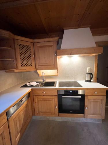 a kitchen with wooden cabinets and a stove top oven at LUSE Living in Maurach