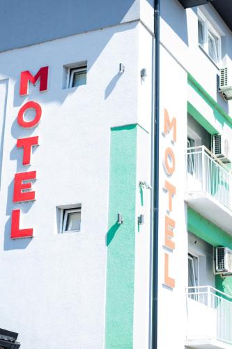 a sign on the side of a white building at Motel Aura in Višegrad