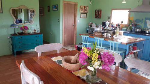 eine Küche mit einem Tisch und einer Blumenvase darauf in der Unterkunft Villa Andalucia in Chonchi