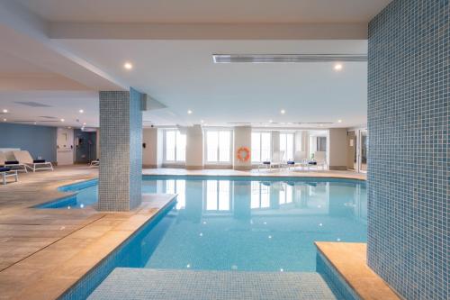 a large swimming pool with blue water in a building at Waterfront in Sliema