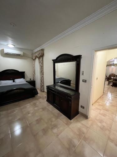a bedroom with a bed and a large mirror at Karnak Flats in Luxor