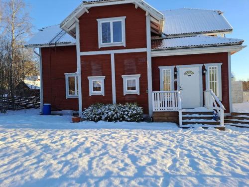 a red house with snow in front of it at Röda villan 