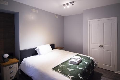 1 dormitorio con 1 cama con 2 toallas en The Black Isle Retreat en Inverness