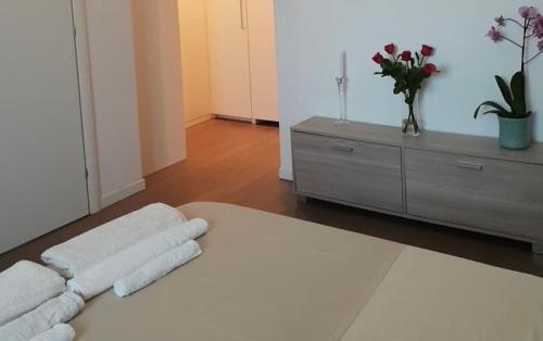 a white bedroom with a dresser and a bed with towels at Liguria Luxury in Florence