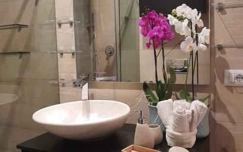 a bathroom with a sink and flowers on a counter at Liguria Luxury in Florence