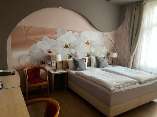 1 dormitorio con 1 cama grande con flores en la pared en Pension Oase, en Berlín