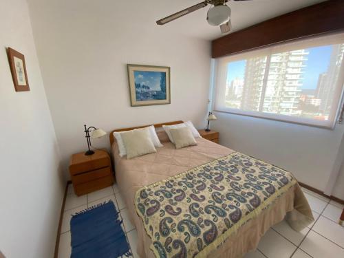 1 dormitorio con cama y ventana grande en Apartamento edificio Cap Ferrat en la mansa Punta del Este, en Punta del Este