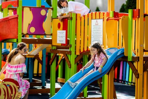 two girls playing on a slide at a playground at Prestige Deluxe Hotel Aquapark Club - All inclusive in Golden Sands