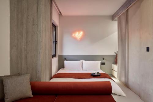 a small bedroom with a bed and a couch at The Newel Metaxourgeio in Athens