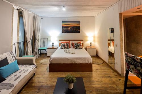 ポルトにあるGuest H4U - Porto River Viewのベッドとソファ付きのホテルルーム