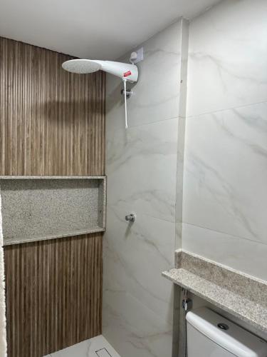 La salle de bains est pourvue d'une douche en marbre blanc. dans l'établissement Porto Galinhas frente mar Mikonos, à Ipojuca