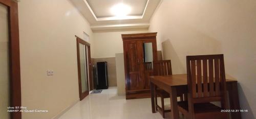 a dining room with a wooden table and chairs at Pandawa Beach Homestay in Uluwatu