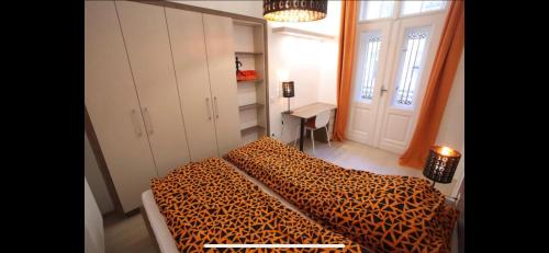 een slaapkamer met een bed met luipaardprint en een bureau bij B39 Benczúr Apartment in Boedapest