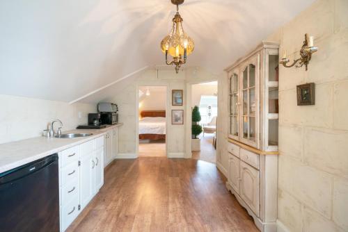 a kitchen with white cabinets and a chandelier at Lion's Head B&B in Niagara Falls