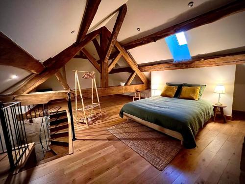 1 dormitorio con 1 cama en una habitación con techos de madera en Chambres Privées des HAMY au coeur du parc national, en Arc-en-Barrois