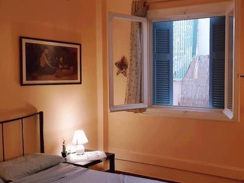 een slaapkamer met een bed en een raam met uitzicht bij Little Chill in Athene