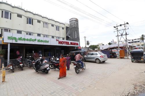 HiriyūrNEW HOTEL SURYA LODGE的一群人骑摩托车站在街上