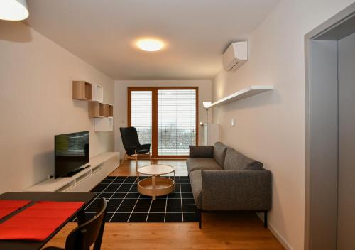 - un salon avec un canapé et une table dans l'établissement EFI Residence Holzova 28, à Brno
