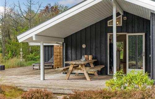 a black house with a picnic table on a deck at Awesome Home In Skagen With Wifi in Skagen