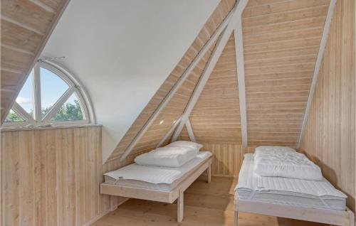スケーエンにあるNice Home In Skagen With Kitchenのベッド2台と窓が備わる客室です。