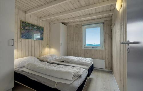 a bedroom with two beds in a room with a window at Amazing Home In Hirtshals With Indoor Swimming Pool, Sauna And 4 Bedrooms in Hirtshals