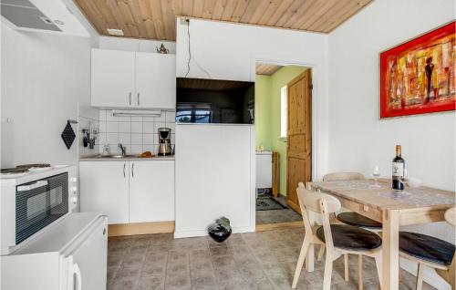 イェリングにある1 Bedroom Amazing Apartment In Hjørringの白いキャビネットと木製のテーブルのあるキッチン