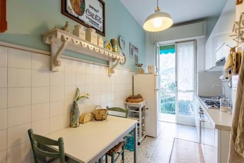 a kitchen with a table and chairs in a room at JOIVY Stylish flat with balcony near Rapallo Castle in Rapallo