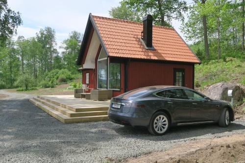 un coche aparcado frente a una casa pequeña en Lovely house on beautiful private lakeside estate!, 