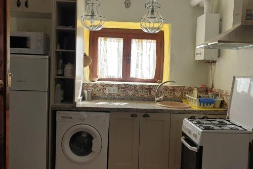 a kitchen with a washing machine and a window at Preciosa casita rural en la sierra de Segur a, Cazorla y las Villas in Pontones