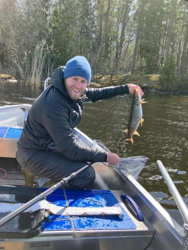 a man in a boat with a fish in his hand at Lovely house on beautiful private lakeside estate! in Bunn