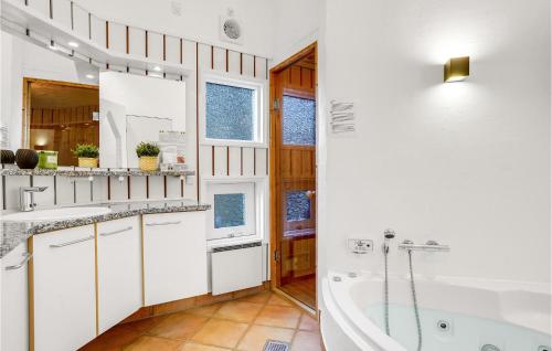 biała łazienka z wanną i umywalką w obiekcie Awesome Home In Lkken With Kitchen w mieście Løkken