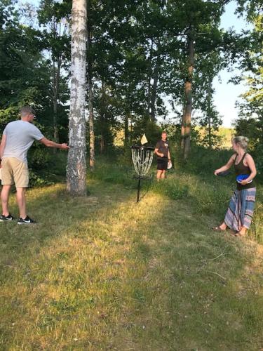 a group of people playing frisbee golf in a field at Lovely house on beautiful private lakeside estate! in Bunn