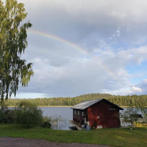a small red house sitting on the side of a lake at Lovely house on beautiful private lakeside estate! in Bunn