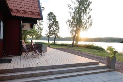 a deck with chairs sitting on the side of a house at Lovely house on beautiful private lakeside estate! in Bunn
