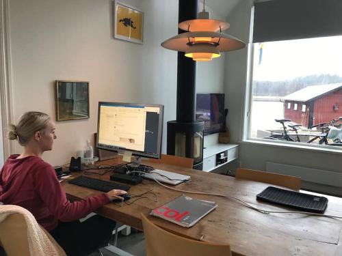 a woman sitting at a desk with a computer at Lovely house on beautiful private lakeside estate! in Bunn