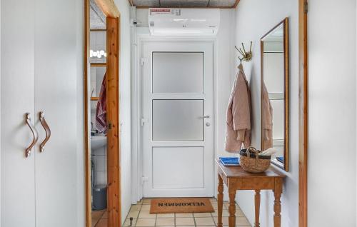 a hallway with a door and a table and a mirror at Awesome Apartment In Løkken With Wifi in Løkken